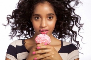 Young woman eating cupcake, studio shot